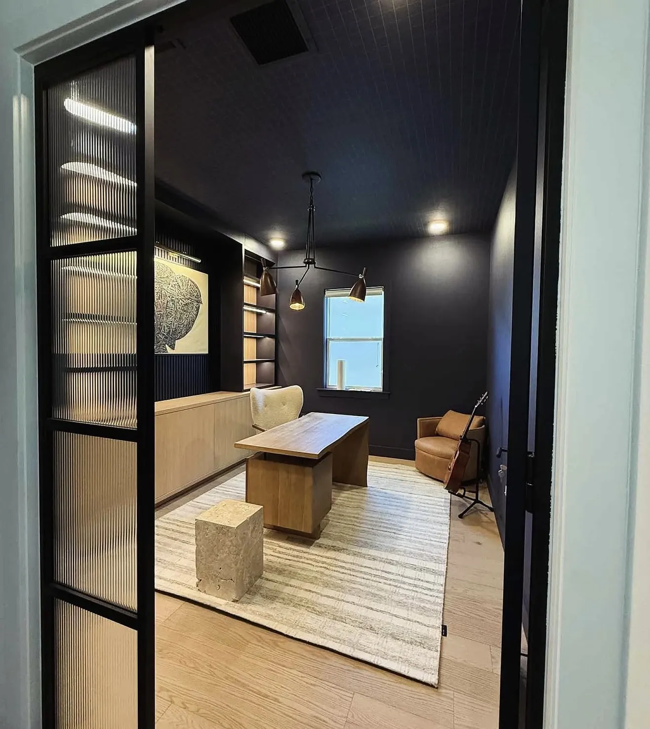 Home office behind steel-frame glass doors by CWL Construction