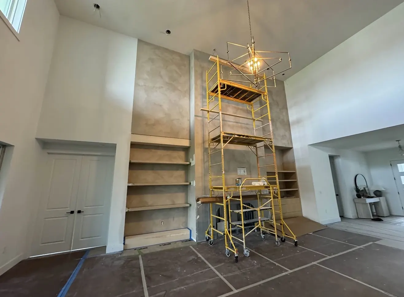 Feature wall with built-in shelving under construction, scaffolding in place
