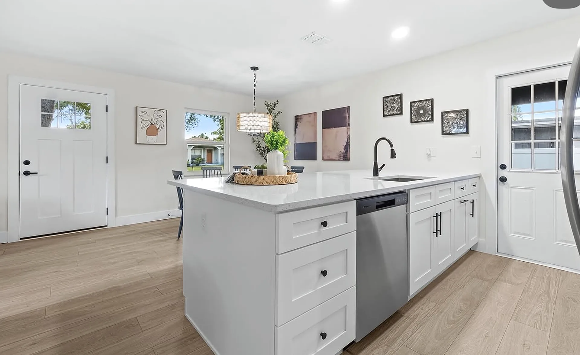 Bright open kitchen remodel with white shaker cabinets and island by CWL Construction